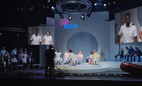 Gesamtes Bühnenbild als Talkshow-Setting mit Livekamera, Videoprojektion, Publikumsrängen und den Hauptfiguren in John Adams' The Death of Klinghoffer.